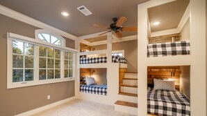 A multi-level bedroom with bunk beds, a ceiling fan, and a large window. - Waterfront 5000 sq. ft. on cove, boat dock & 2 large decks, Media & Game Room. (Hot Springs Village)