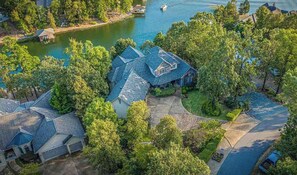 An aerial view of a residential area with multiple houses, a lake, and a dock.