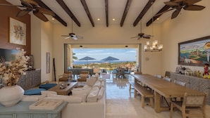 A spacious dining area with a long wooden table, multiple chairs, and ceiling fans. - Gorgeous Views, 2 Masters, 3 more En Suites (Cabo San Lucas)