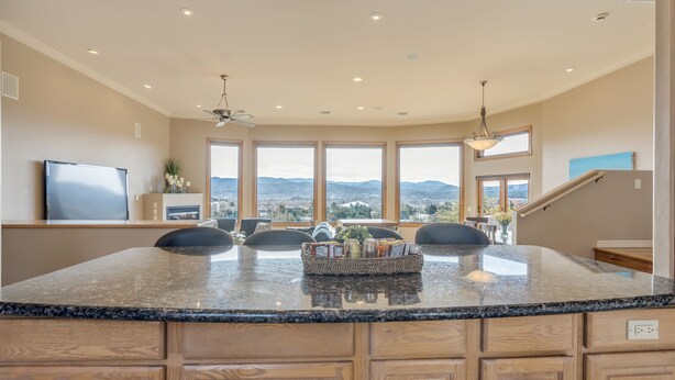 A kitchen with a large island, wooden cabinets, and a view of the mountains. - "The View in Prescott," a Custom Home With 3 Patios + Fire Pit, Near Downtown (Prescott)