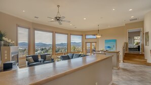A spacious kitchen with a wooden island, large windows offering a mountain view, and a ceiling fan. - "The View in Prescott," a Custom Home With 3 Patios + Fire Pit, Near Downtown (Prescott)