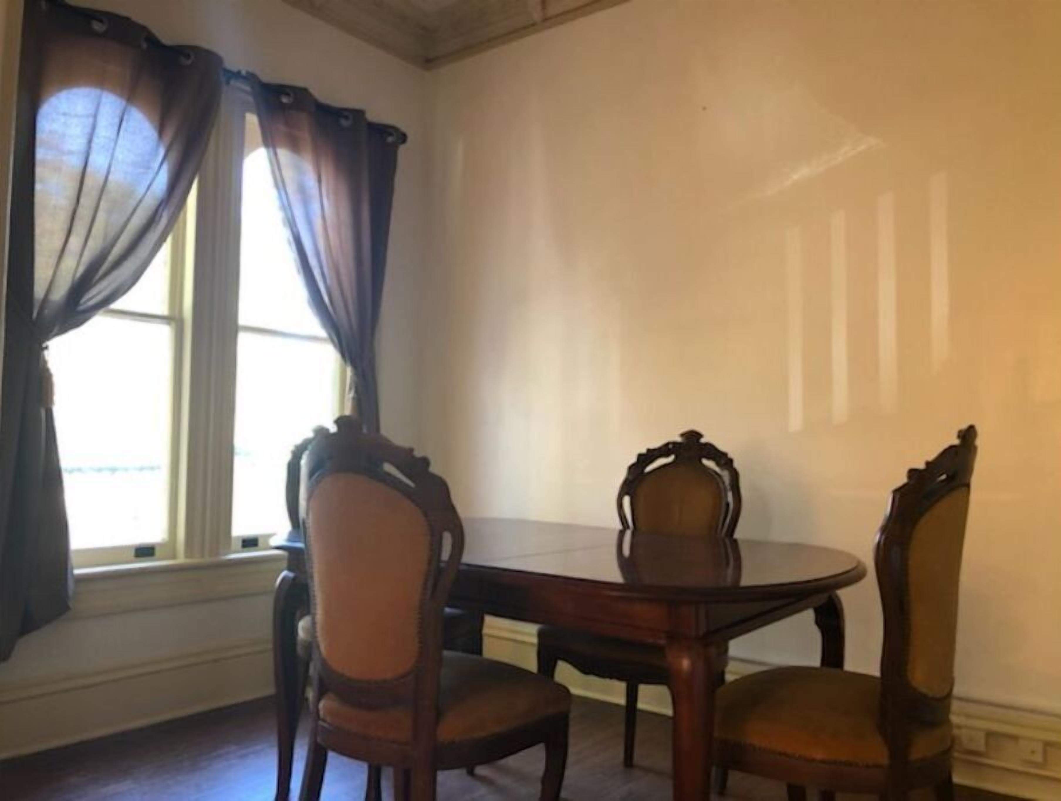 A dining room with a round table and four chairs.