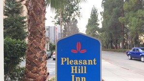 Cartell del Pleasant Hill Inn, amb fons blau, logotip vermell i el nom de l'allotjament en lletres daurades.