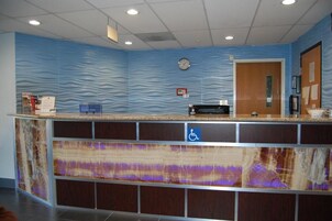A reception area with a wavy blue wall, a clock, and a door.