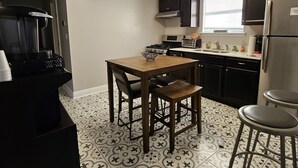 A compact kitchen with a dining table, a coffee machine, and a refrigerator. - NOLA Living In The Heart Of Many Attractions (New Orleans)