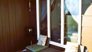 Une pièce baignée de lumière, avec une fenêtre, une chaise en osier et une petite table.