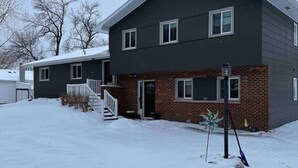 Un immeuble résidentiel de deux étages, doté d’une façade en briques et d’un toit foncé.