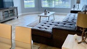 A spacious living room with a sectional sofa, a flat-screen TV, and a ceiling fan. - BEAUTIFUL LUXURY APARTMENT CLOSE DISNEY (Kissimmee)