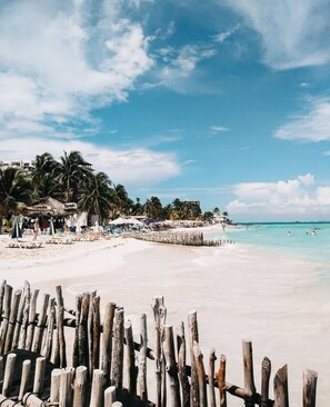 Una playa cerca, sillas reclinables de playa, toallas de playa