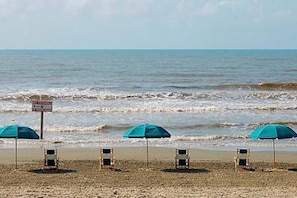 Relax on the beach with comfortable chairs and shaded umbrellas.