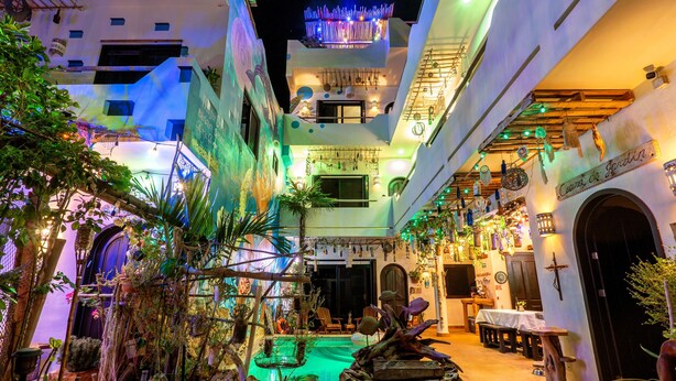 Un patio con piscina, zonas de estar y un restaurante.
