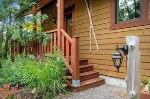 A wooden house with a porch, steps, and a lantern post. - Tremblant-Mont Blanc/SPA/Intimacy (St-Faustin lac carré)