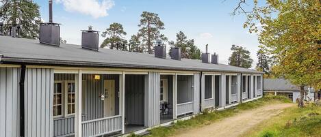 Een rij vakantiehuisjes met aanbouwde veranda's, elk met een schoorsteen.