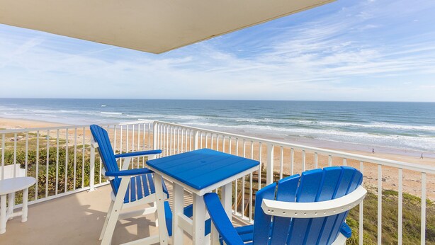 A balcony with a view of the beach and ocean. -      Breathtaking Oceanfront Condo with stunning  Panoramic Views.  (Ormond Beach)