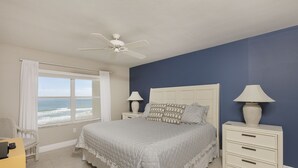 A bedroom with a bed, nightstands, a desk, and a chair. -      Breathtaking Oceanfront Condo with stunning  Panoramic Views.  (Ormond Beach)