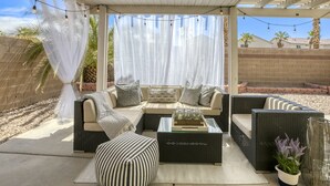 An outdoor patio with a covered seating area, including sofas and a coffee table. - The Cloud9: Stylish, spacious and comfort at its finest (Las Vegas)