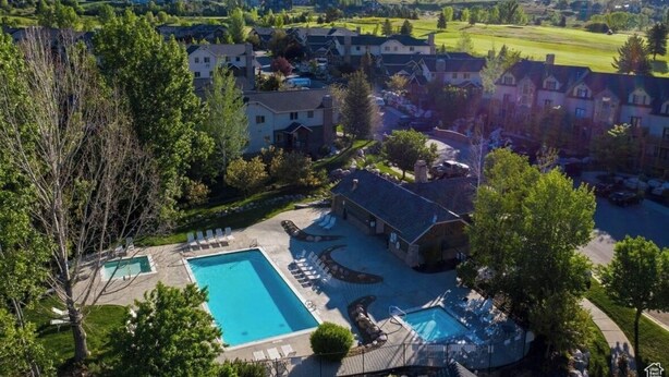 A residential area with a swimming pool, lounge chairs, and a view of the surrounding landscape. - Mountain Condo Near Snowbasin, Powder & Nordic (Eden)