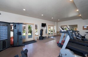 A gym with exercise equipment, a punching bag, and a treadmill.