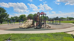 A playground with a slide, climbing structures, and a small pavilion. - Spacious SW Omaha Home Near I-80, Garage Game Room, Family-Friendly, Safe Area! (Omaha)