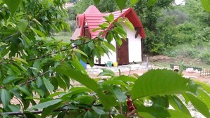 A rustic building with a red roof, surrounded by lush greenery and cherry trees. - Immaculate 2-Bed Cottage near Krka Waterfalls (Rupe)