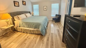A bedroom with a bed, bedside tables, a chair, a dresser, and a TV. - 4110 David & Jennie’s Place (Missouri City)
