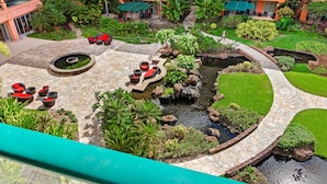 A landscaped courtyard with a central water feature, seating areas, and surrounding greenery.