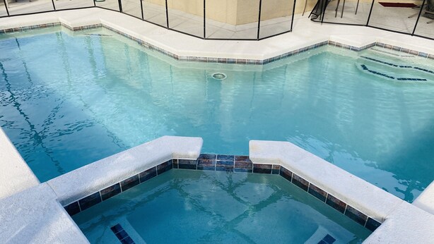 A clear view of a swimming pool with a tiled edge and a central drain.