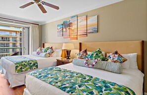 A hotel room with two beds, a balcony, and a view of the ocean.