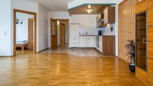Une cuisine spacieuse avec des meubles en bois, un réfrigérateur et une plante en pot.