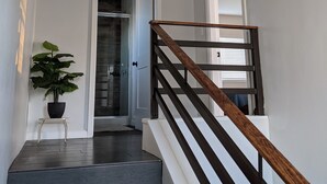 A staircase with dark wooden railings and a potted plant at the base. - Brand New Studio, Confortable, and gated parking, close to downtown. (Ensenada)