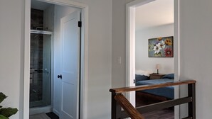 A bedroom with a bed, a nightstand, and a painting on the wall. - Brand New Studio, Confortable, and gated parking, close to downtown. (Ensenada)