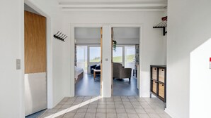 A modern interior with a hallway leading to a living area. - Cozy Brenderup Apartment on the Beach (Middelfart)