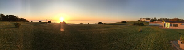 A grassy field with a house and a small building in the distance. - Beachfront Apartment D, 2 Bedrooms, Free Parking (Middelfart)
