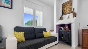 Ein modernes Wohnzimmer mit einem grauen Sofa, einem Kamin und einer Buddha-Statue an der Wand.