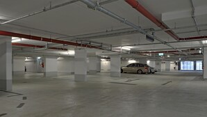 A multi-level parking garage with concrete floors and white pillars.
