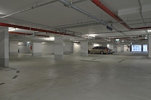 Un parking à plusieurs niveaux, doté de planchers en béton et de piliers blancs.