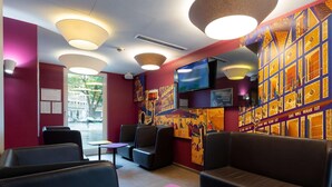 A modern interior with seating, a TV, and artwork on the walls.