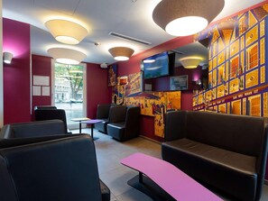 Een modern interieur met zitplaatsen, een televisie en kunstwerken aan de muur.