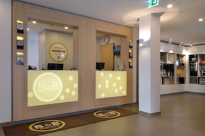 Ein Hotel-Empfangsbereich mit einem Hinweis auf ein Bed & Breakfast, einer Uhr und einem Fernsehbildschirm.