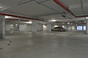 Een meerlaags parkeergarage met betonnen vloeren en witte zuilen.