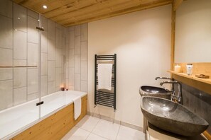 Un baño moderno con bañera, lavamanos independiente y toallero.