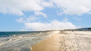 A beach with a sandy shore, ocean waves, and a clear sky. - Hilton Head | Island Beach Stay | Pool & Beach | 2BR (Hilton Head)