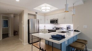 A modern kitchen with a central island, stainless steel appliances, and pendant lighting. - Hilton Head | Island Beach Stay | Pool & Beach | 2BR (Hilton Head)