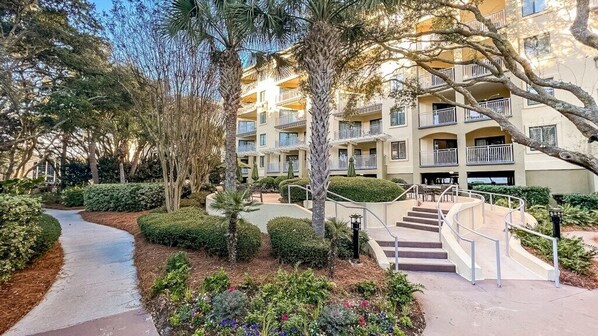 A multi-story hotel with a central courtyard, a curved pathway, and a staircase leading to the upper floors.