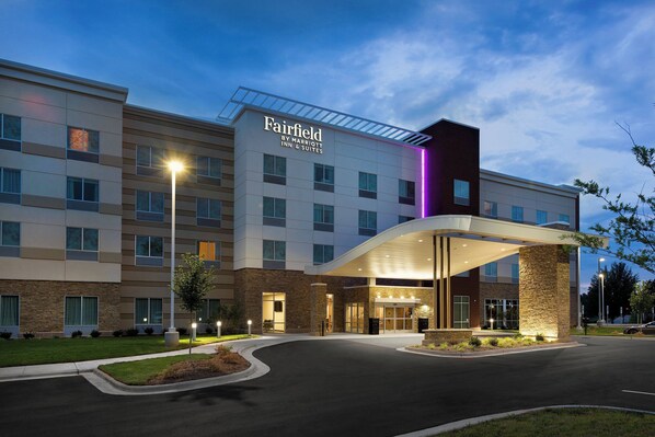 A Fairfield by Marriott Inn & Suites building with a modern design, featuring a large entrance and a covered walkway.
