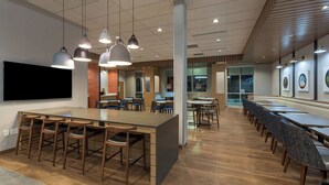 A spacious dining area with a long counter, multiple tables, and chairs. - Fairfield Inn & Suites by Marriott Statesville (Statesville)