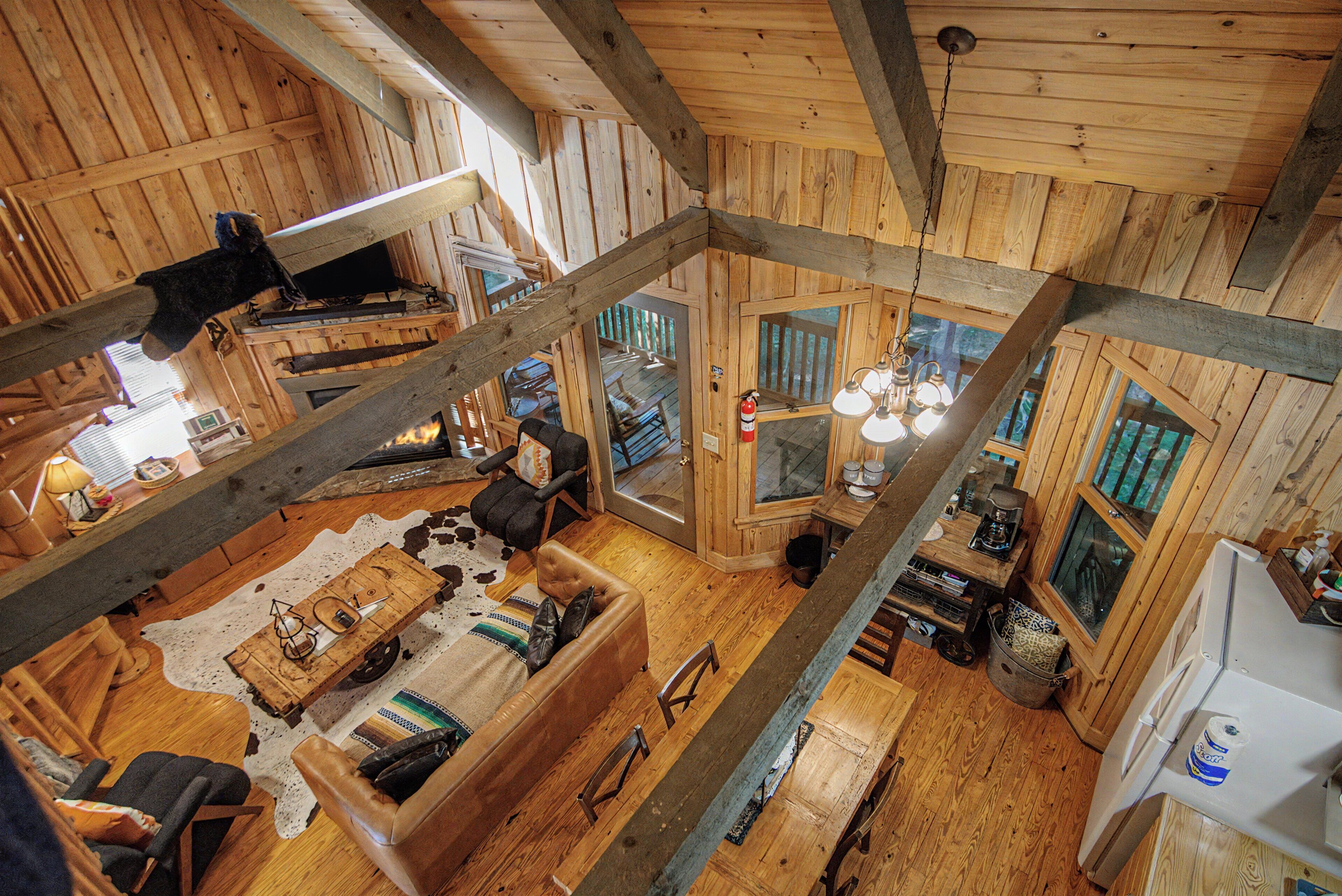 A cabin with a loft-style bedroom, a dining area, and a kitchen.