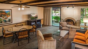 Una sala de estar con chimenea, comedor y sofá.