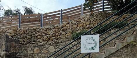 A staircase leading to a stone wall with a sign for Dolphin Apartments & Studios.