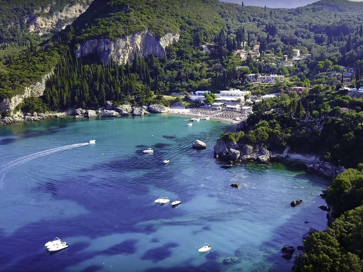 Une ville côtière aux eaux turquoise et limpides, où l’on peut admirer des bateaux et de hautes falaises rocheuses.